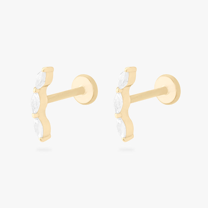 This is an image of a pair of 14k gold flatback studs with 3 clear, pear-shaped cz's in a curved line.
