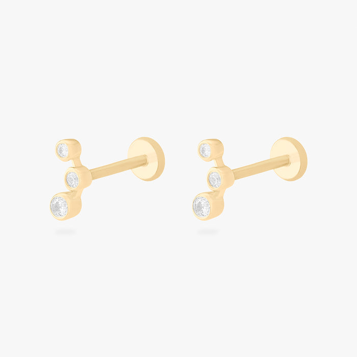 This is an image of a pair of 14k gold flatback studs with 3 clear cz bezels in a cluster shape.