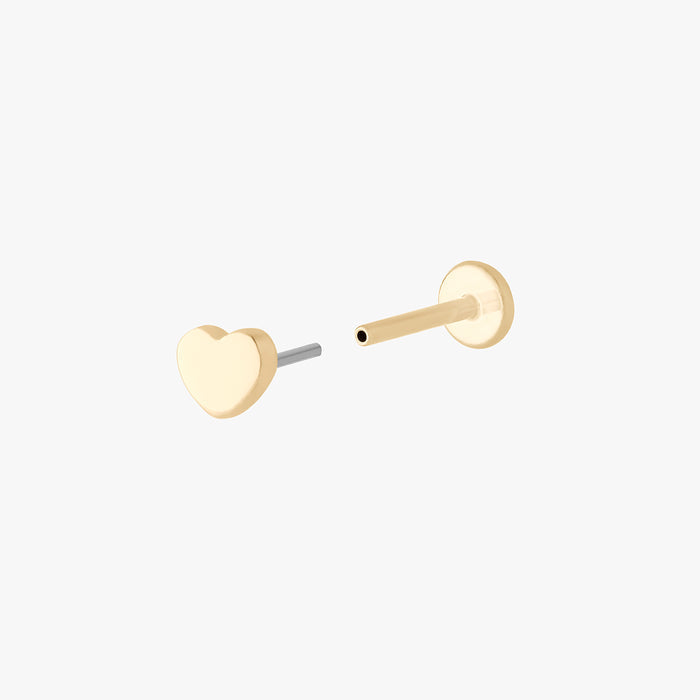 This is an image of a 14k gold flatback stud in the shape of a heart separated from labret.