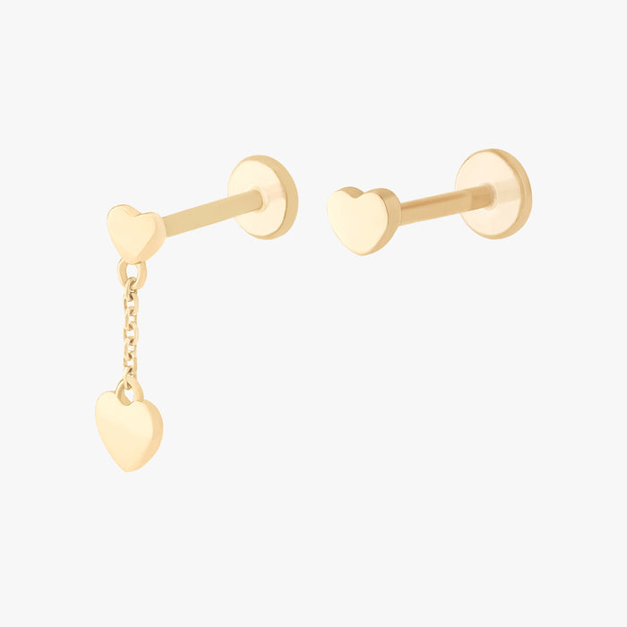 This image shows a set of earrings. This set contains one 14k Yellow Gold heart dangle flatback stud and a 14k Yellow Gold heart flatback stud