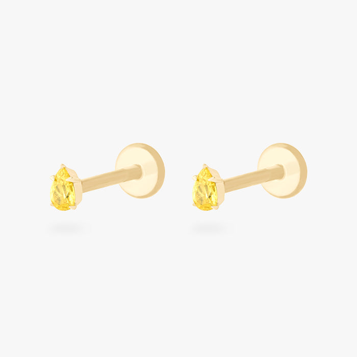 This is an image of a pair of 14K gold flatback studs with pear shaped topaz cz stones against a white background.