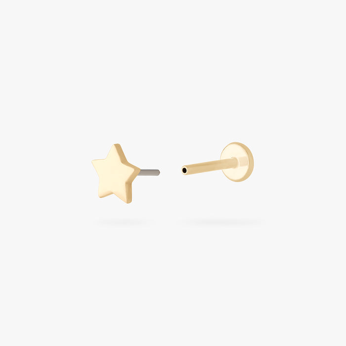 This is an image of a 14K gold flatback stud that is in the shape of a star separated from labret