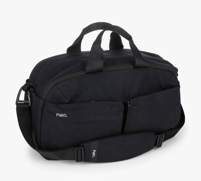 Black duffel bag with shoulder strap, front zip pockets, and 'Pakt.' logo.