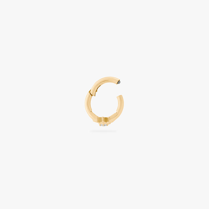 This is an image of a gold-toned titanium clicker with a twinkle-star shape that features a crystal CZ in the center. This clicker is 6mm in diameter.