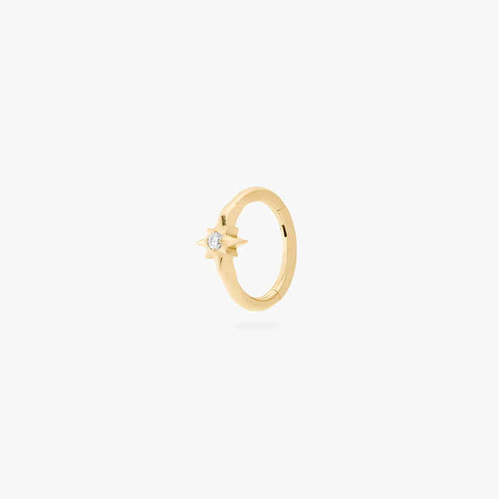 A single gold earring with a star-shaped stone, shown against a white background.