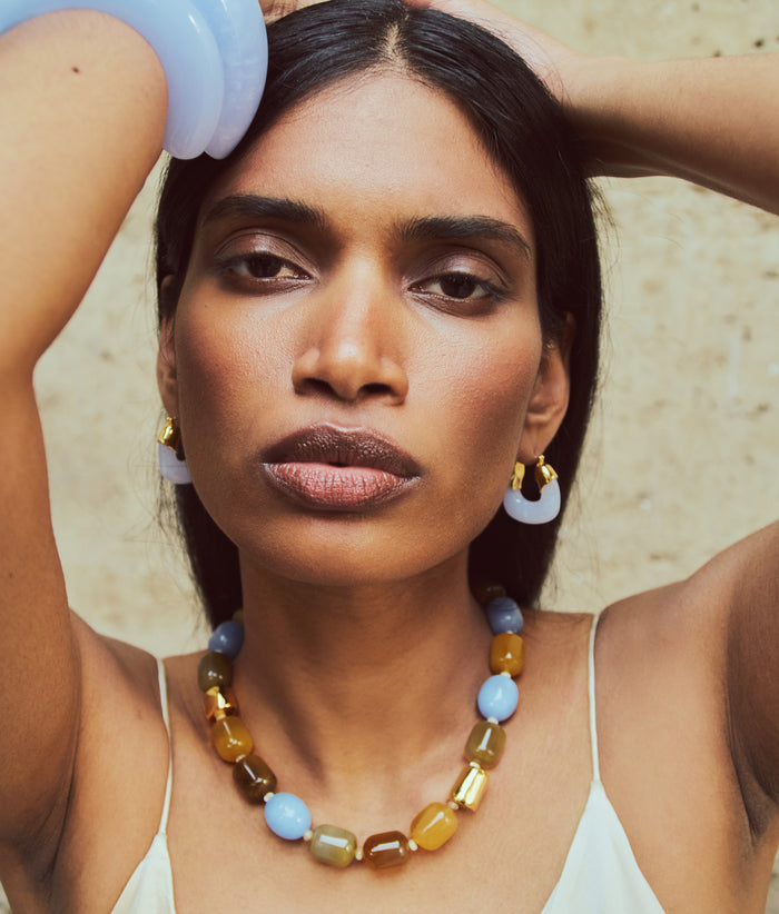 Model with hands on head wears Cuffs and Mini Organic Hoops in Blue Lace and Palomino Necklace