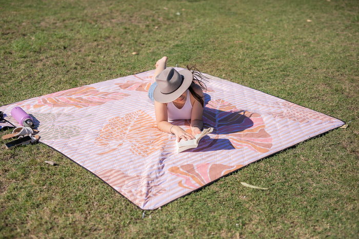 Image of a person enjoying a sunny picnic while reading