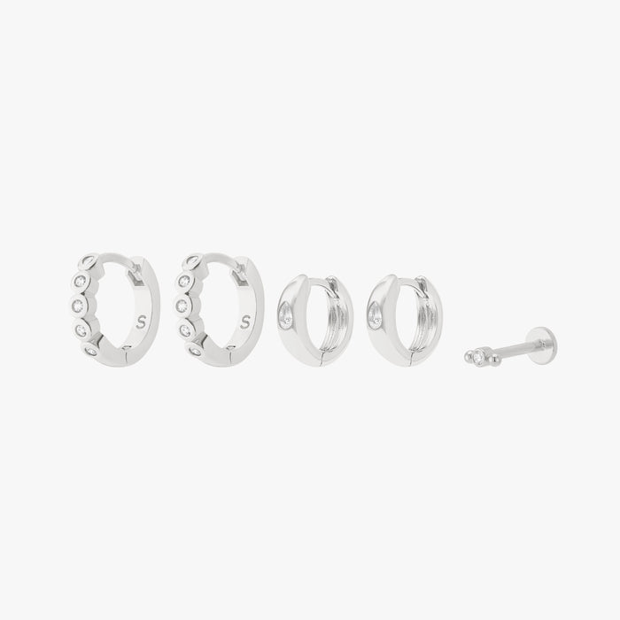 This is an image displaying the silver/clear version of the Bezel Starter Set. The set includes a pair of CZ Bezel Huggies, a pair of Chunky Pear CZ Huggies, and a single Micro Bezel Cluster Flatback Stud.