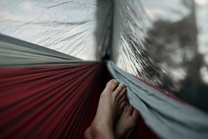 Feet visible from inside Nakie's Bug Net, as the person relaxes in a hammock