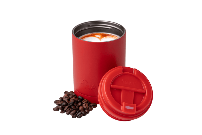 Red insulated coffee cup with matching lid and coffee beans displayed alongside, filled with latte art