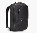 Three-quarter view of Cero Travel backpack in black showing vertical front zipper, padded shoulder straps, diamond ripstop fabric texture, and tan zipper pulls on white background