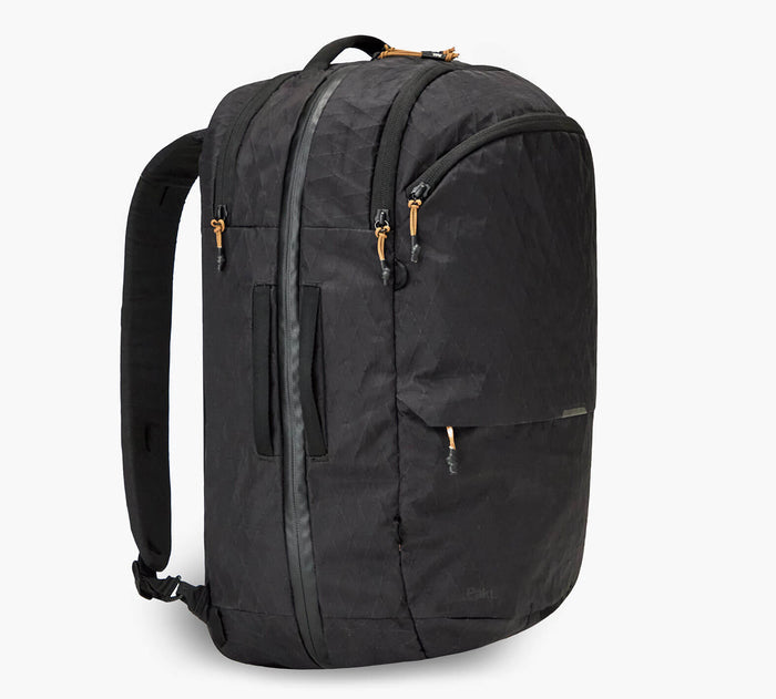 Three-quarter view of Cero Travel backpack in black showing vertical front zipper, padded shoulder straps, diamond ripstop fabric texture, and tan zipper pulls on white background