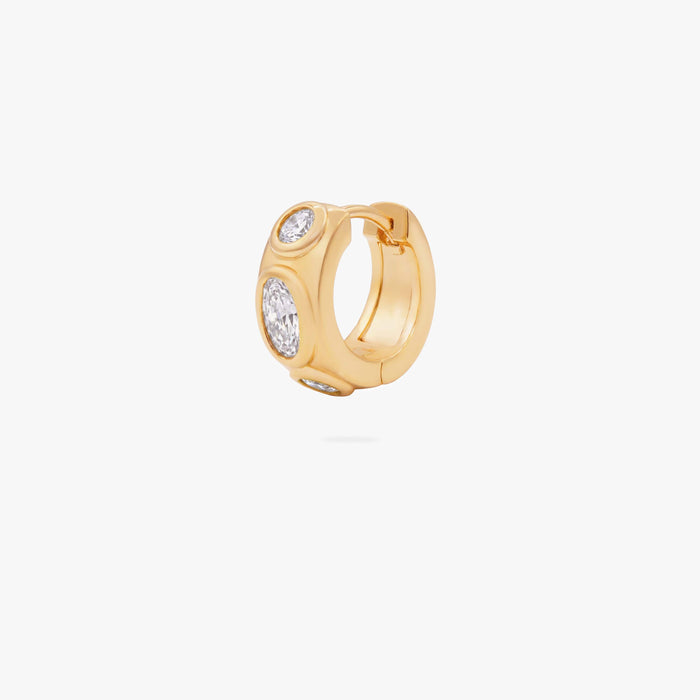 this image shows the front of a 14k gold plated huggie with three clear circular cz stones