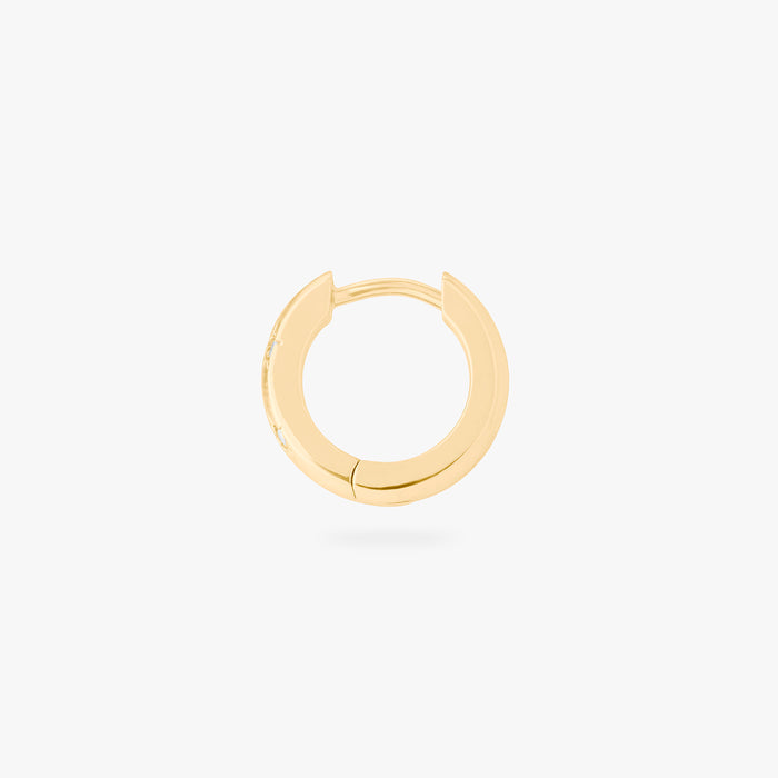 This image displays a 14K gold plated chunky huggie that features twinkle star shaped engravings with crystal CZ stones throughout the huggie against a white background. This image focuses on the side view of the huggie.