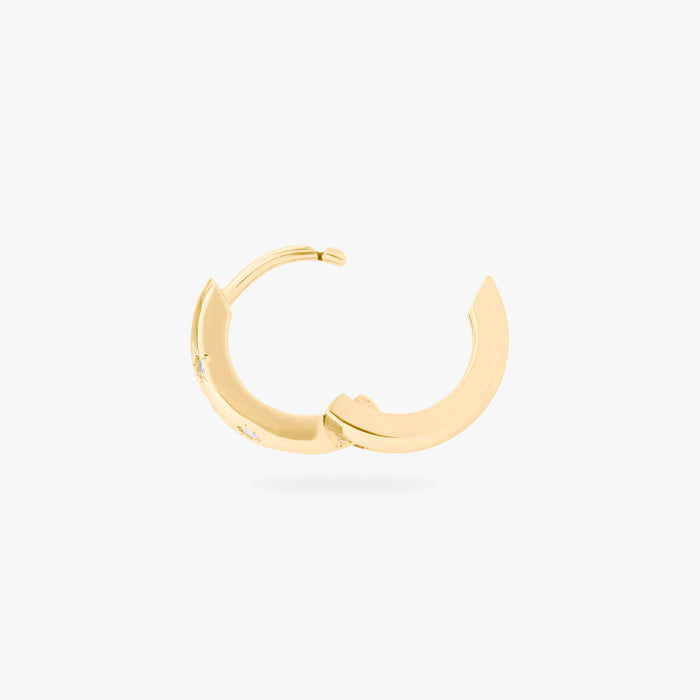 This image displays a 14K gold plated chunky huggie that features twinkle star shaped engravings with crystal CZ stones throughout the huggie against a white background. This image displays the huggie hinged open.