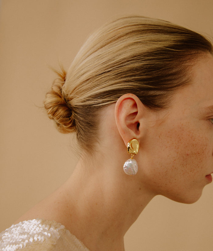 Model in close-up wears Coin Reflection Earrings in Gold