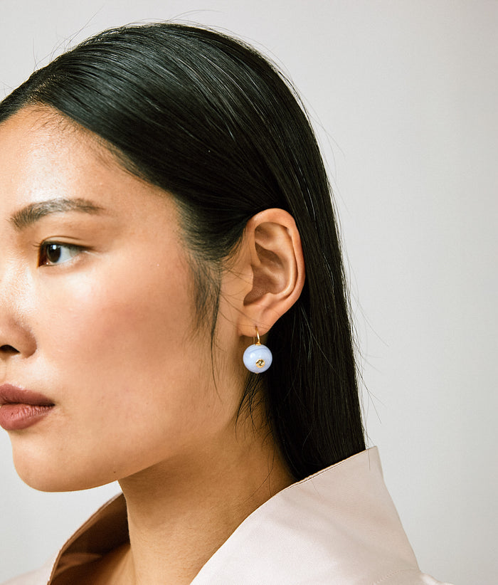 Model in profile wearing Comet Earrings in Blue Agate