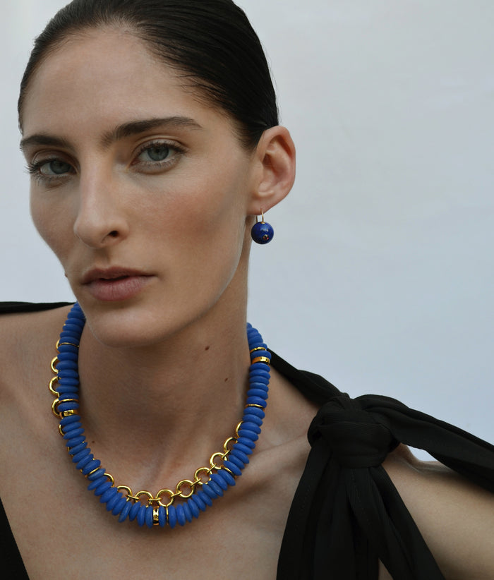 Model in black bow top wears Comet earrings in Lapis with Laguna Necklace in Dark Blue and Gold Mood Necklace
