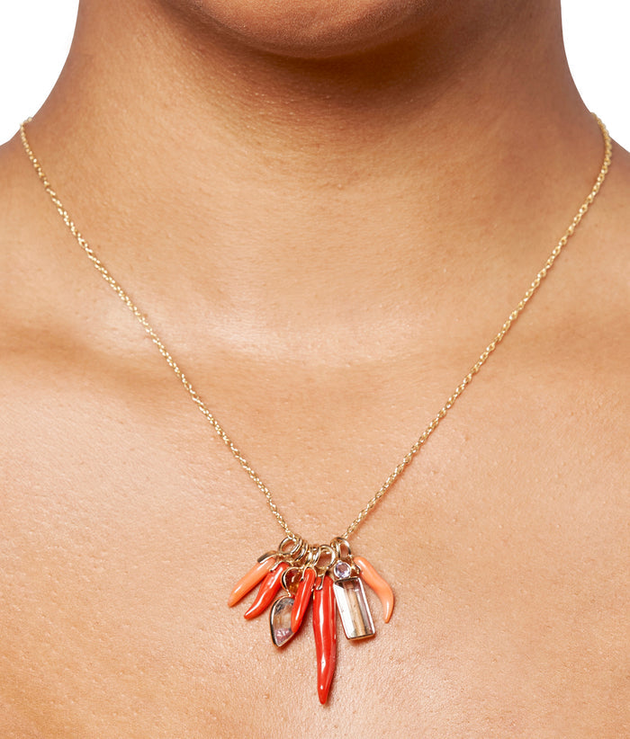 Close-up of model wearing gold chain with Exclusive Fine charms, including Coral Horn 14K Necklace Charm.