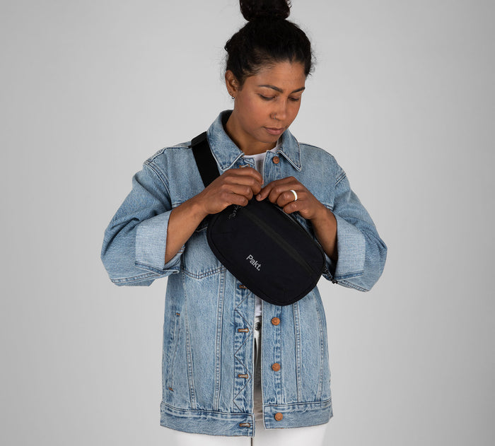 Front view of Everyday 3L Sling in Black worn across chest, showing exterior zip pocket and adjustable strap