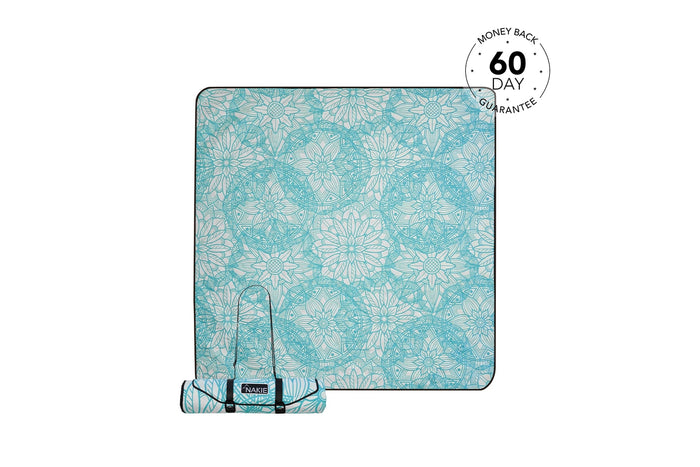 Turquoise and cream floral patterned picnic blanket rolled with carrying straps