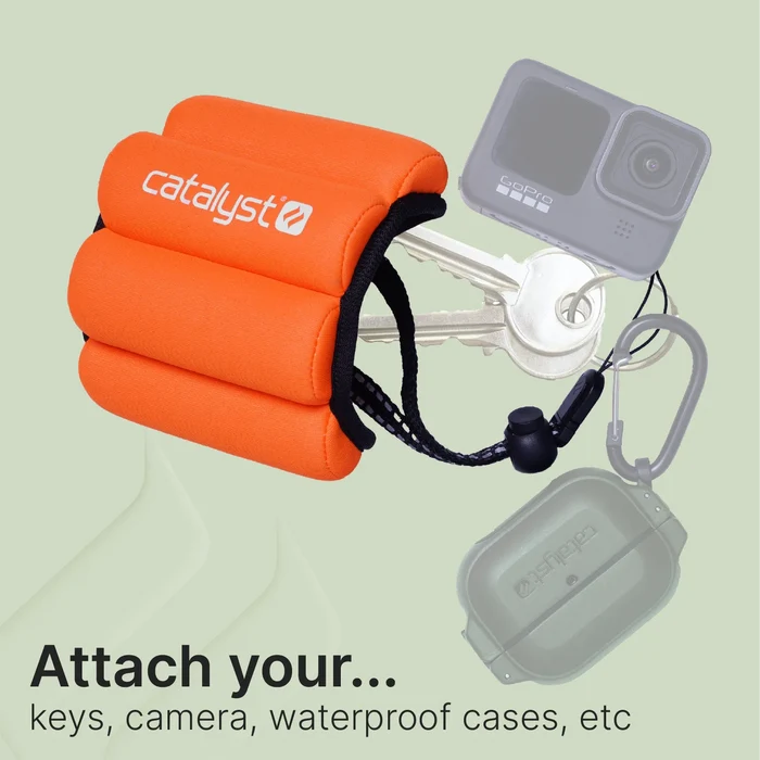 An orange Catalyst Case US Floating Wrist Lanyard with adjustable cord is shown holding keys, a GoPro camera, and a waterproof case. The light green background displays: ÃƒÂ¢Ã¢â€šÂ¬Ã…â€œAttach yourÃƒÂ¢Ã¢â€šÂ¬Ã‚Â¦ keys, camera, waterproof cases, etc.ÃƒÂ¢Ã¢â€šÂ¬Ã‚Â.