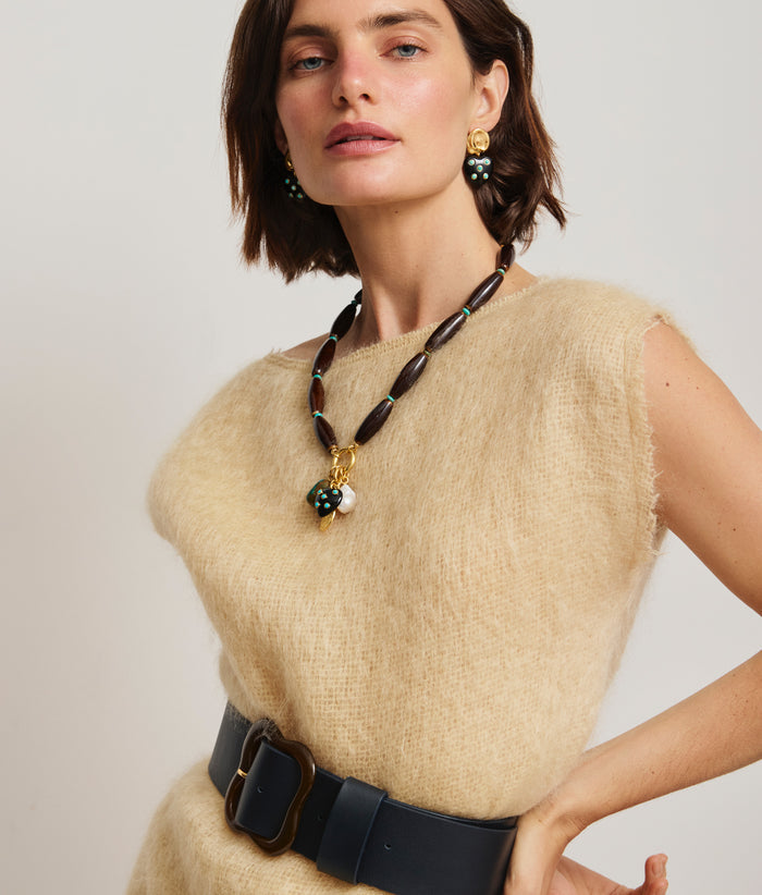 Model in fuzzy tan dress wears Amore Heart Earrings, Marilla Necklace and Florence Belt