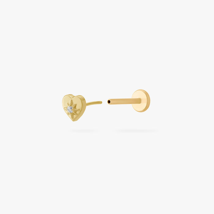 This is an image of a gold-toned titanium flatback stud in the shape of a heart with a twinkle shaped star within it, and a crystal CZ within that. This earring is separated from the flatback post and facing the camera.