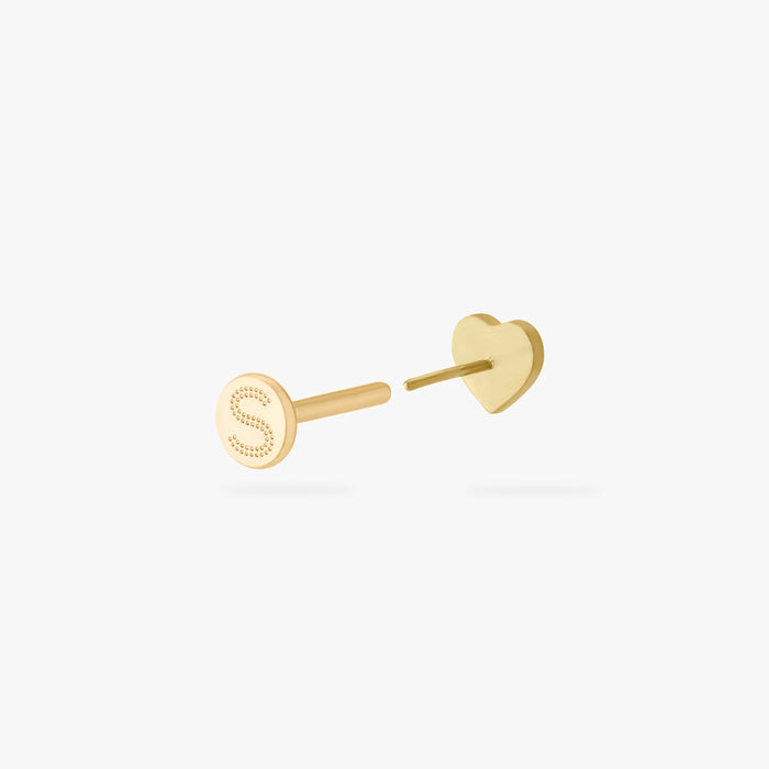 This is an image of a gold-toned titanium flatback stud in the shape of a heart with a twinkle shaped star within it, and a crystal CZ within that. This earring is separated from the flatback post and facing away from the camera.