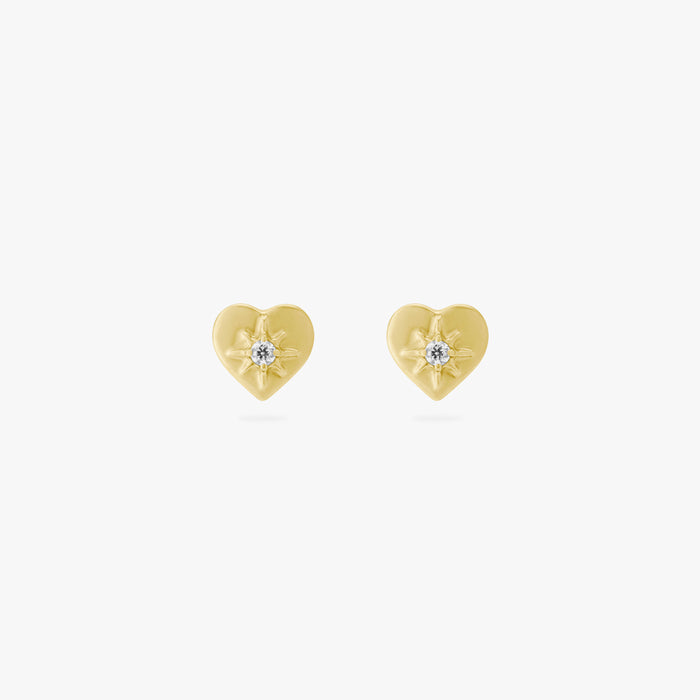 This is an image of a pair of gold-toned titanium flatback studs in the shape of hearts with twinkle shaped stars within them, and crystal CZs within that.