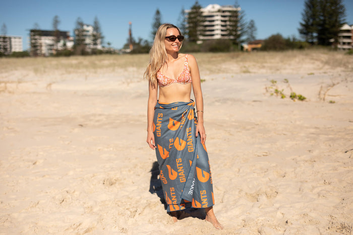 GWS Giants recycled sand-free beach towel in gray and orange, worn as wrap on beach