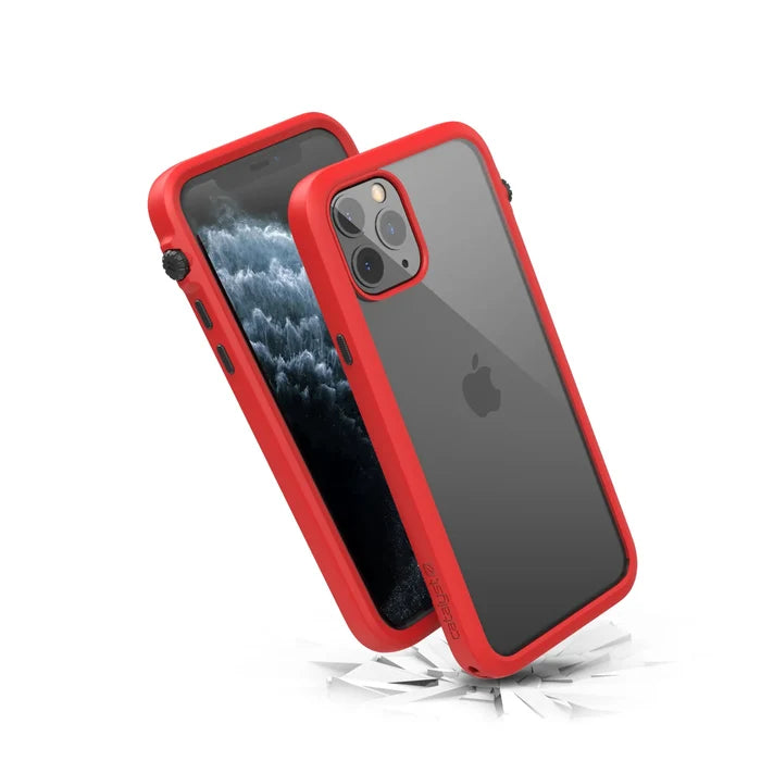 Two iPhone 11 Pros in Catalyst Case US Impact Protection Cases with clear backs and red bumpers are shownÃƒÂ¢Ã¢â€šÂ¬Ã¢â‚¬Âone displaying the screen, the other the Apple logo and triple camera. MIL-STD 810G-rated for durability, they rest above cracked shards to show impact resistance.