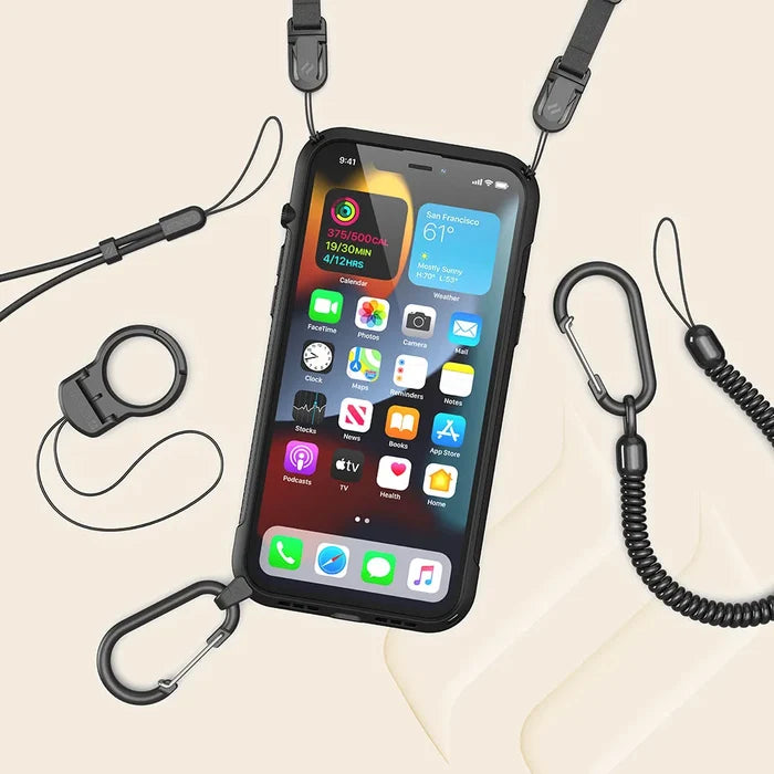An iPhone 13 mini in a black Catalyst Case US Vibe Case (MagSafe compatible) with attached straps, carabiners, and a coiled lanyard is displayed on a beige background, surrounded by accessories. The screen shows app icons and weather widget.