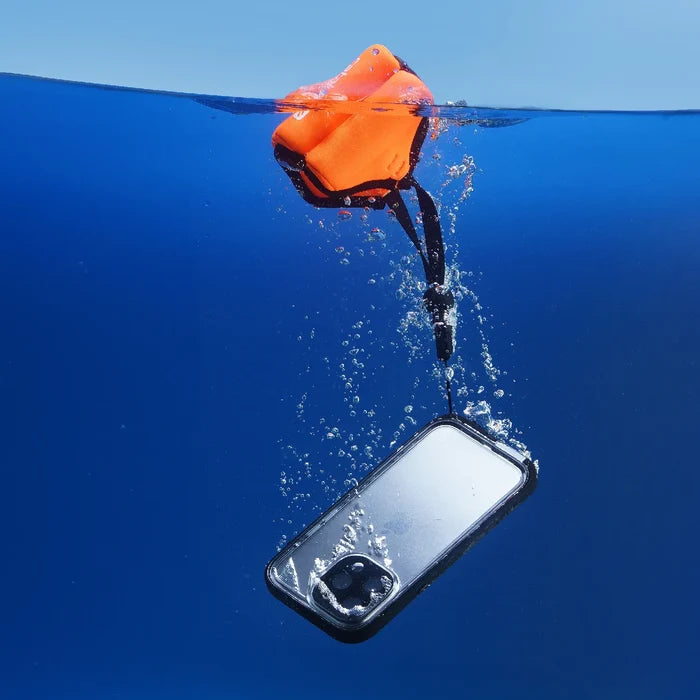 An iPhone 14 Plus in the Catalyst Case US Waterproof Case—Total Protection—is seen underwater, attached to an orange floating strap at the surface, with bubbles highlighting its submersion and the strap's protective, buoyant function.