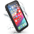 An iPhone XR in a Catalyst Case US waterproof case (Stealth Black) is shown with water splashes, highlighting its protective and water-resistant design. The vibrant screen displays common app icons on a colorful background.