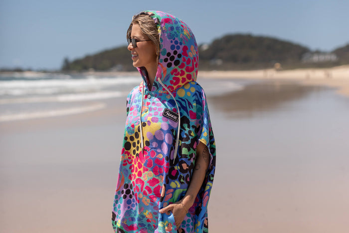 Multicoloured hooded towel with leopard and geometric print, worn on beach at side angle view.