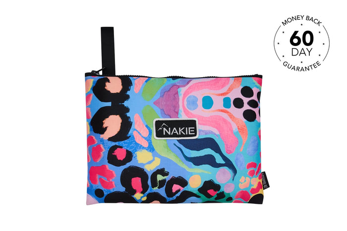 Kasey Rainbow recycled beach towel with colorful abstract pattern, black handle, and Nakie logo label.