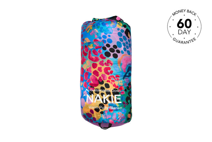 Colorful puffy blanket with multicolor leopard-spot and abstract pattern, compressed in storage pouch, front view