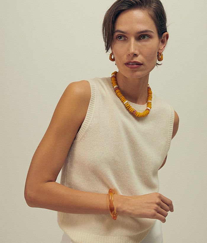Model wears white knit top with Laguna Neclace in Mustard, Organic Hoops in Mocha and Ridge Cuff in Marigold