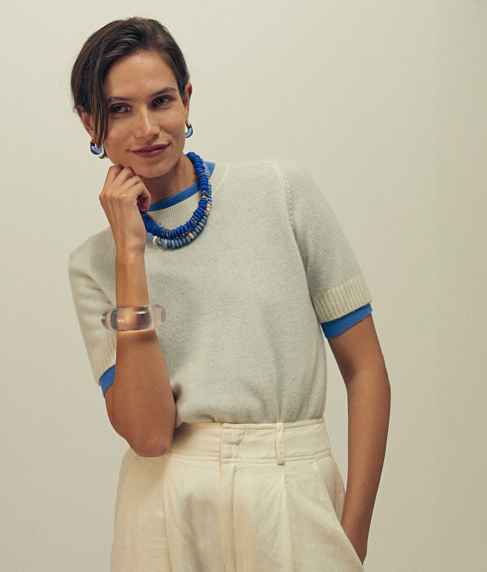 Alt view of model wearing white sweater with blue cuffs, blue Laguna Necklaces and Mini Organic Hoops in Electric.