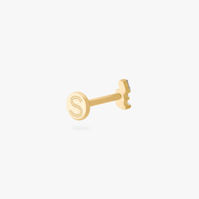 This is an image of a gold-toned titanium flatback stud with 3 micro baguette cut stones placed in a cluster. This image shows the earring facing away from the camera and focuses on the flatback post with the Studs "S".