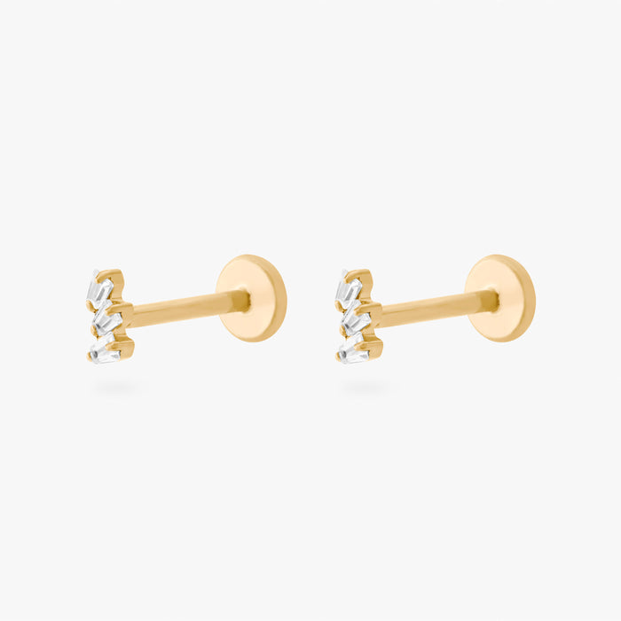 This is an image of a pair of gold-toned titanium flatback studs with 3 micro baguette cut stones placed in a cluster.