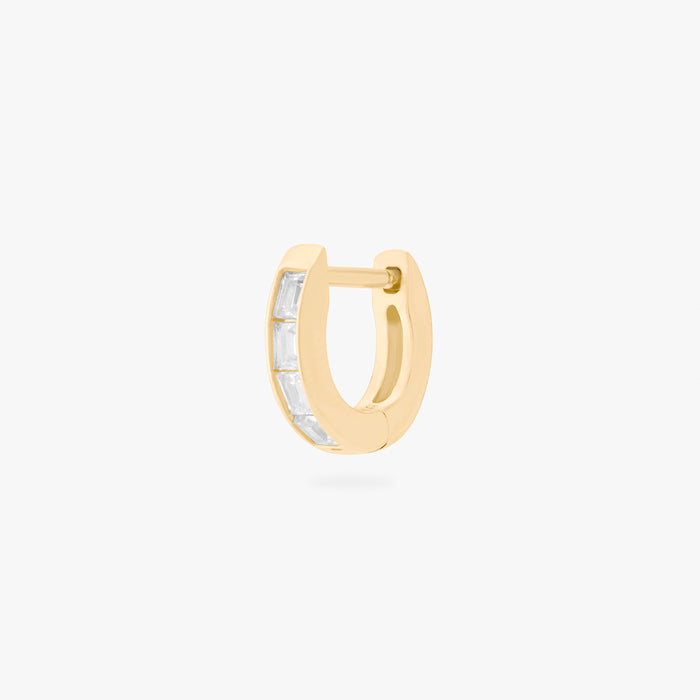 This is an image of a 14K gold plated huggie earring with 4 baguette cut, bezel set crystal CZs along the edge.