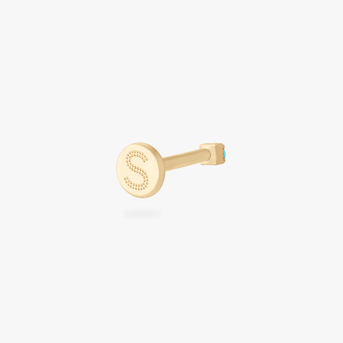 Back angle of a gold flatback stud with a dotted S on the backing