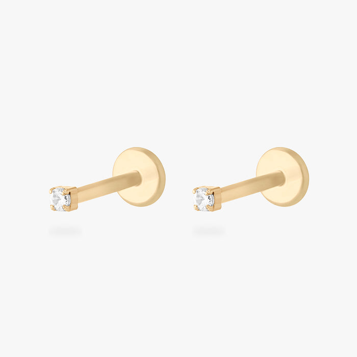 Pair of gold micro CZ flatback stud earrings with small clear stones in prong setting displayed side by side