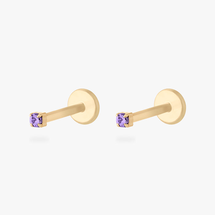 Pair of gold micro CZ flatback stud earrings with small purple stones in prong setting displayed side by side
