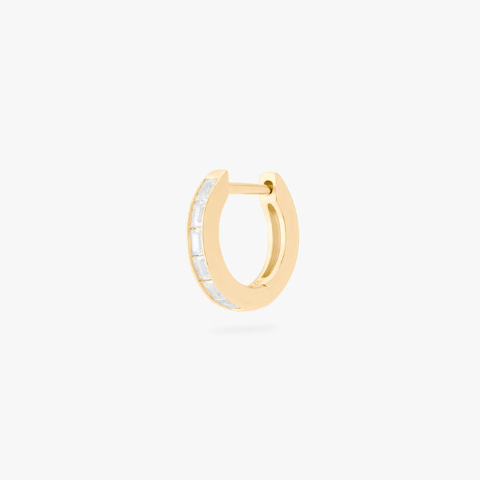 This is an image of a 14K gold plated huggie earring with 6 baguette cut, bezel set crystal CZs along the edge.