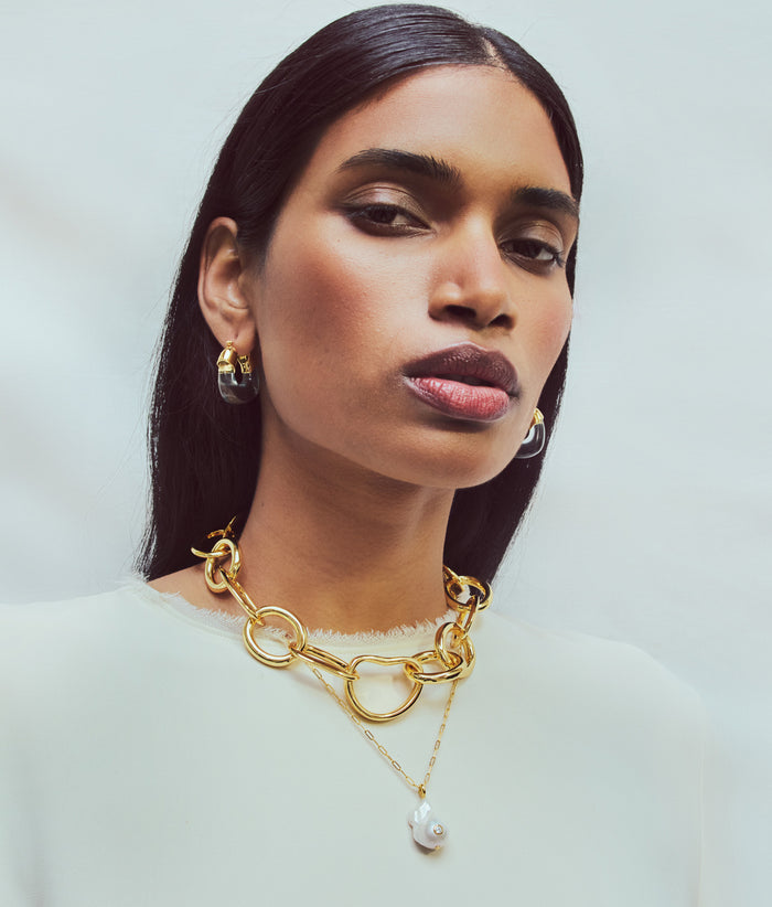 Model wears white top and Mini Organic Hoops in Clear, Porto Chain and Oasis Necklace in Gold