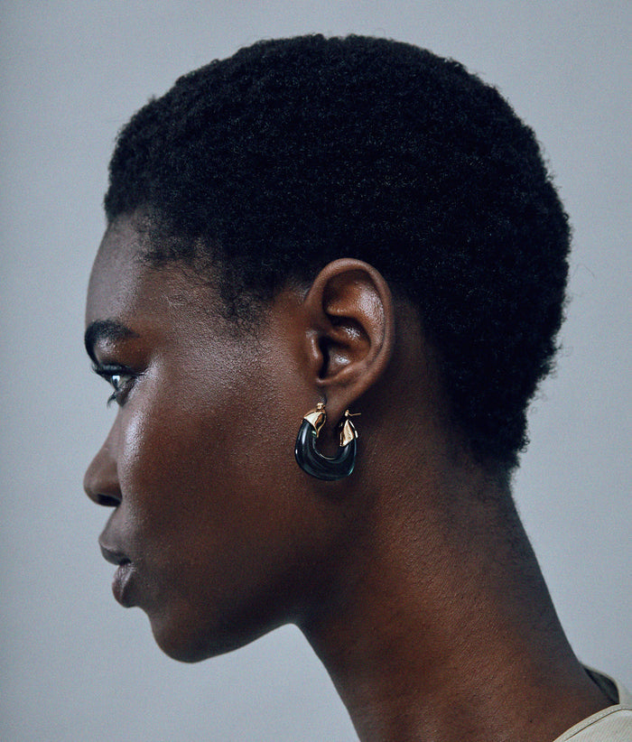 Model on grey background with the Mini Organic Hoops in Forest.