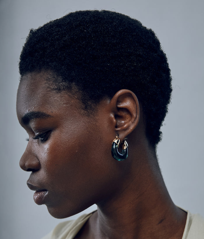 Another angle of model on grey background with the Mini Organic Hoops in Forest.